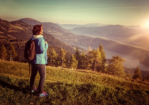 woman standing on mountain enjoying view into valley