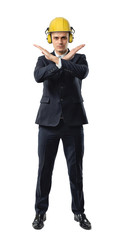 Businessman full height wearing yellow helmet with earphones, giving forbidding stopping sign