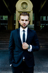 Handsome bearded man wearing suit, portrait shot in urban area