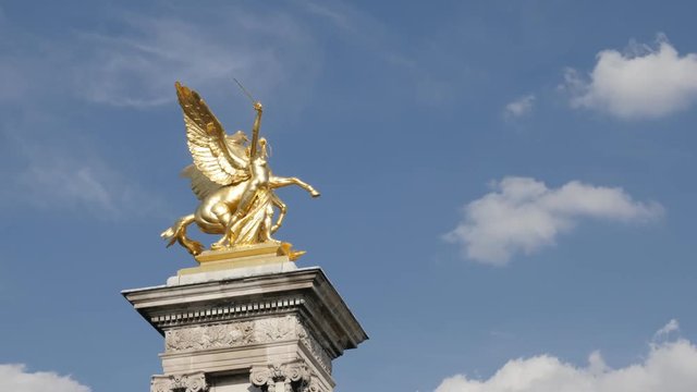 Famous Pont Alexandre III stone columns with golden statues slow tilt 4K 2160p 30fps UltraHD footage - French monument sculptures against blue sky in Paris 3840X2160 UHD tilting video 