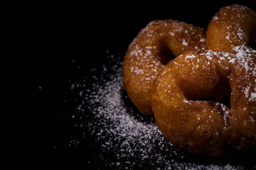 Sprinkling sugar powder on donut