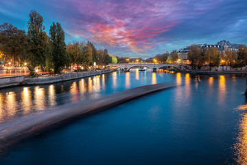Fototapeta premium River Seine in Paris, France at dusk, in autumn. Long exposure of passing boat.