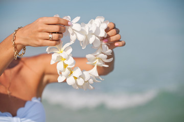 Woman hands holding Flower lei garland of white plumeria