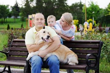 Family on a bench with a retriever