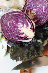 A head of purple cabbage cut in half on the board..