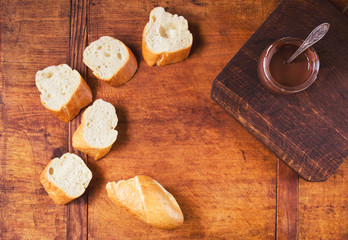 Sweet snack with fresh baguette and chocolate on a wooden table