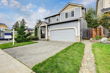 Obraz premium Exterior of large blue house with garage and column porch.