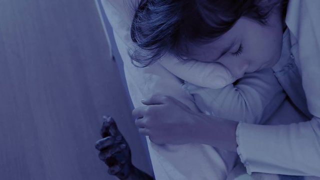 monster coming out from under little girls bed. nightmare child. halloween
