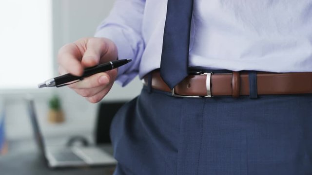 A ballpen visible while a businessman plays with it