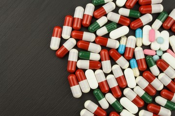 Detailed view of multicolored pills. Pharmaceutical industry. Colorful pills on black background
