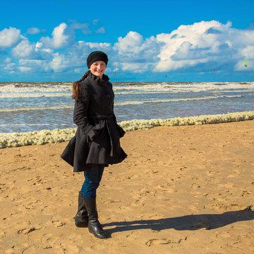 Smiling Happy Woman Dressed In A Coat At The Beach