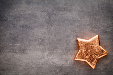 Fototapeta na wymiar Bronze star. Christmas pattern. Background on the gray color.