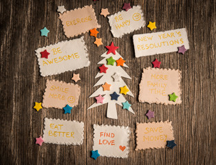 New Year's resolutions and Christmas tree on vinatege wooden backgroun