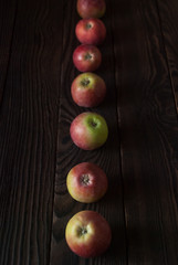 Row of several apples on a wooden surface