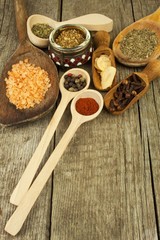 Spice in Wooden spoon. Herbs. Cinnamon and other on a wooden rustic background. Pepper. Large collection of different spices and herbs. Salt, paprika. Sale of spices.
