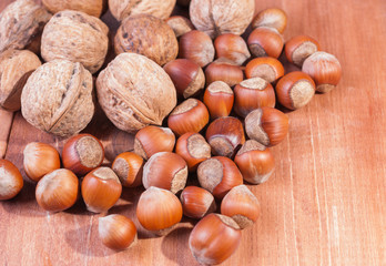 Walnuts and hazelnuts on wooden background