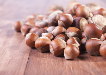 Hazelnuts on wooden background. Focus on the foreground