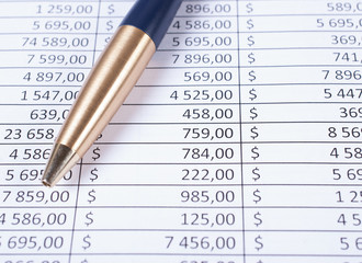Ballpoint pen lying in a corner on printed financial tables