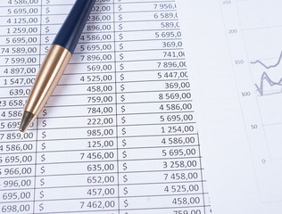 Ballpoint pen lying in a corner on printed financial tables