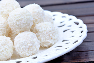 Plate with coconut cookies on table