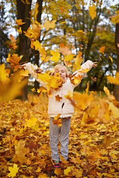  happy little girl laughing and playing in autum