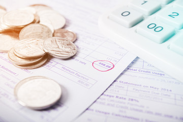 Utility bill with silver coins and calculator