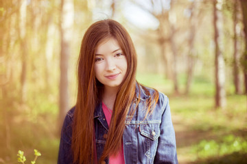 Fototapeta premium Portrait of a girl with long straight brown hair, which fly in t