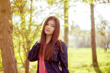 Portrait of a girl with long straight brown hair in a denim jack
