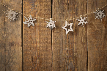 Rope with snowflakes and star on wooden background