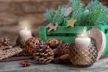 Composition of candle and natural decor on wooden background, close up view