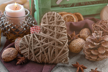 Composition of wicker heart and natural decor on wooden background, close up view