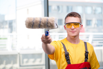 Young construction worker in yellow coveralls