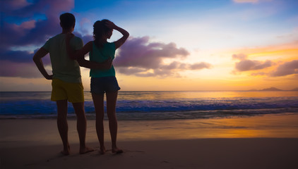 Fototapeta premium sunset silhouette of young couple in love at beach