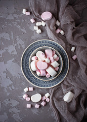 Obraz na płótnie Canvas White and pink marshmallows on gray concrete background