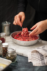 Beef Minced meat bowl. Female hand mixing beef minced meat in bowl.
