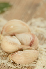 Garlic cloves on a table with flour