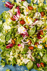 Obraz na płótnie Canvas Green mixed salad leaves with tomatoes, corn, green olives. Preparing green salad. 