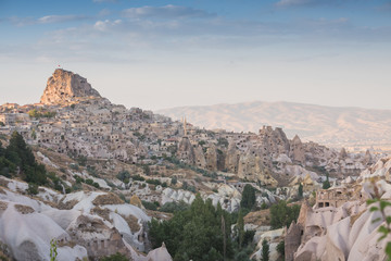 Fototapeta na wymiar Ancient town and a castle of Uchisar dug from a mountains after sunrise, Cappadocia, Turkey