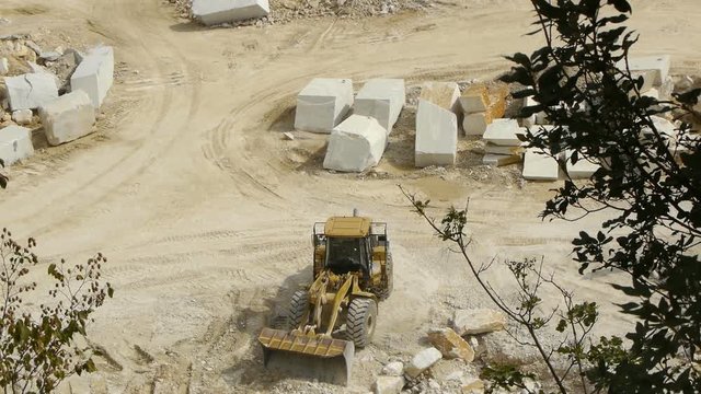 Marble blocks and front loader machine in stone quarry