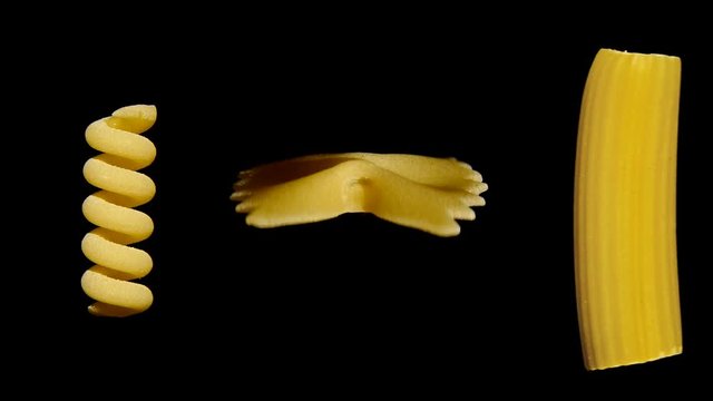 Three different tipes of short dry pasta shapes isolated on black