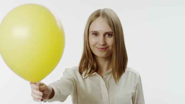 Portrait of smiling woman with yellow balloon