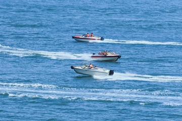 Speed boats passing each other in a blue sea
