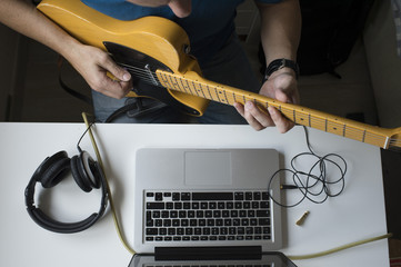 .Man teaching himself to play guitar at home