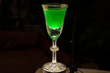 glass of wine and mojito green candles on a black background