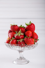 Fresh strawberries in a glass vase on a white background. Vegetarian and healthily cooking concept.selective focus.