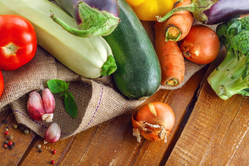 Organic vegetables on a rustic wooden table for healthy food cooking. Top view, above.