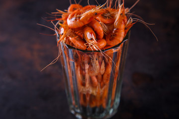 Prawn shrimp cooked in a glass beaker on a dark background.Crustaceans and seafood. selective focus.