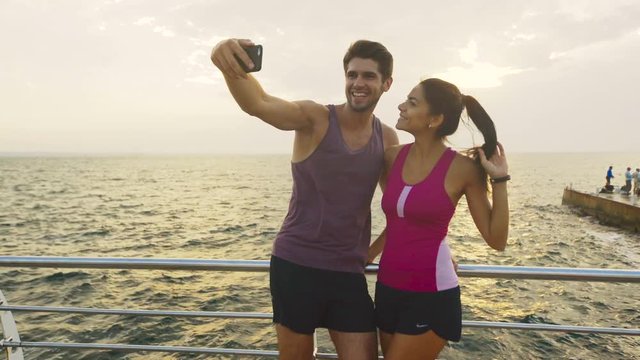 Two young people taking selfies after morning jog.
