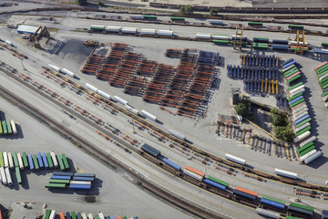 Aerial of unloading container trailers at railway terminal, USA. Railroad tracks, containers, trailers