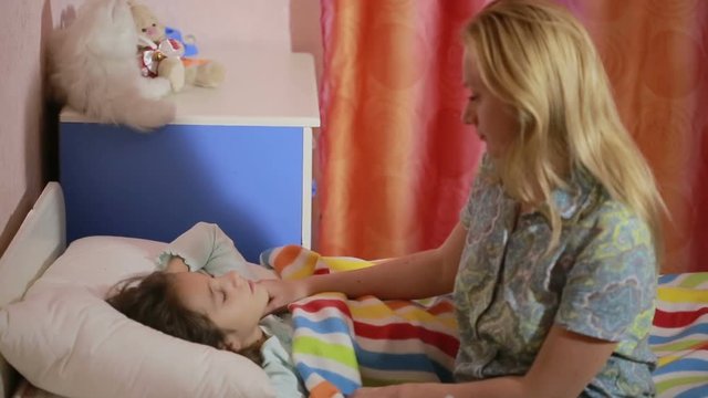 mother puts daughter to bed. baby sleep